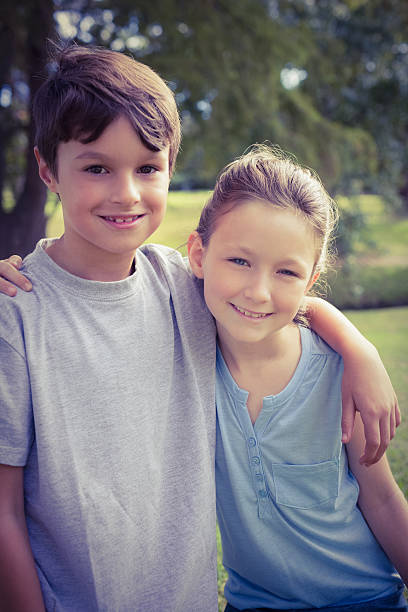 istock Smiling sibling looking at camera in the park 482586502