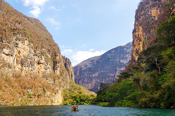 Boat in a Canyon A small boat in the Sumidero Canyon in Chiapas, Mexico mexico chiapas cañón del sumidero stock pictures, royalty-free photos & images