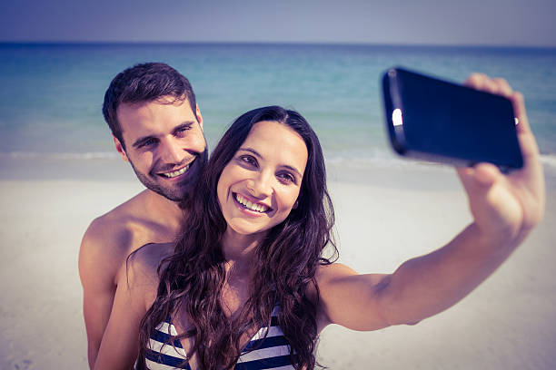 istock Happy couple taking a selfie at the beach 482586578