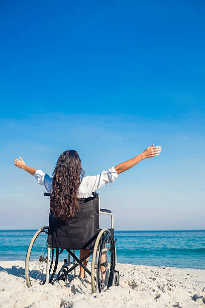 istock Disabled woman with arms outstretched at the beach 482587654
