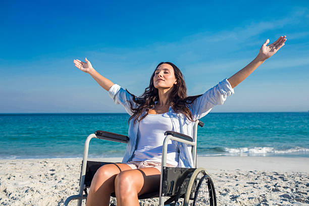 istock Disabled woman with arms outstretched at the beach 482587668