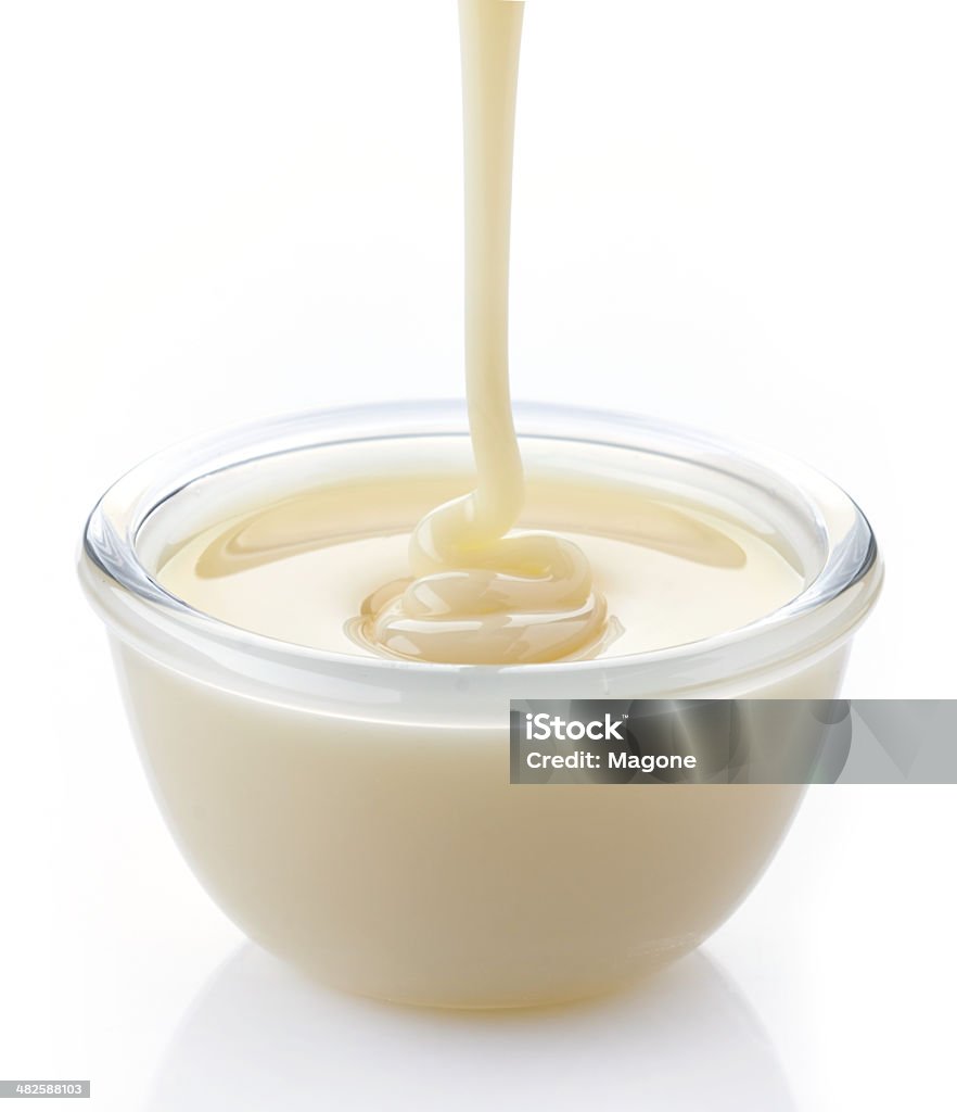 pouring condensed milk with sugar in a bowl Bowl Stock Photo