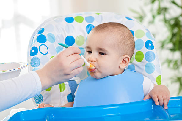 istock Little beautiful baby eating fruit 482589312