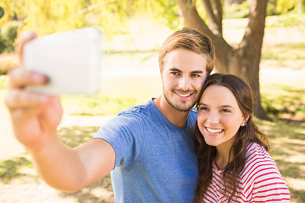 istock Cute couple doing selfie in the park 482596504