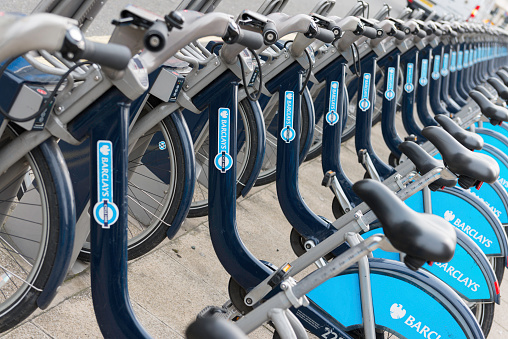 London, United Kingdom - March 22, 2014: Row of hire bikes lined up in a docking station in London. This bicycle sharing system was first introduced in London in July 2010, and is designed to provide a non-polluting transport alternative to more traditional services. Sponsored by Barclays Bank, the scheme is also known as Barclays Cycle Hire of 'Boris Bikes'.