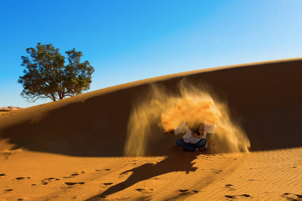 istock Berber playing and throwing with sands in Desert Sahara, creatin 482597675