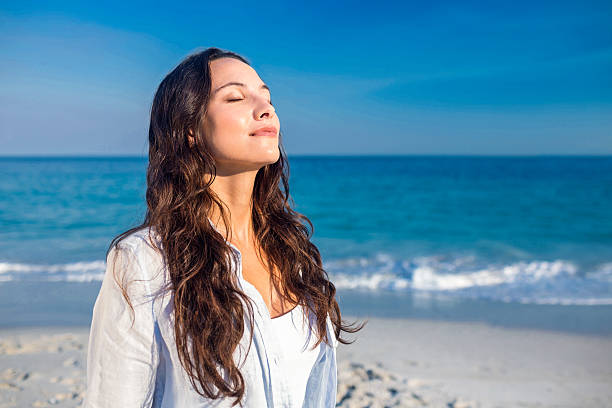 istock Happy woman with eyes closed at the beach 482598196