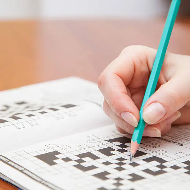Crossword puzzle close-up.Hand doing crossword