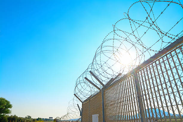 metal fence with barbwire stock photo
