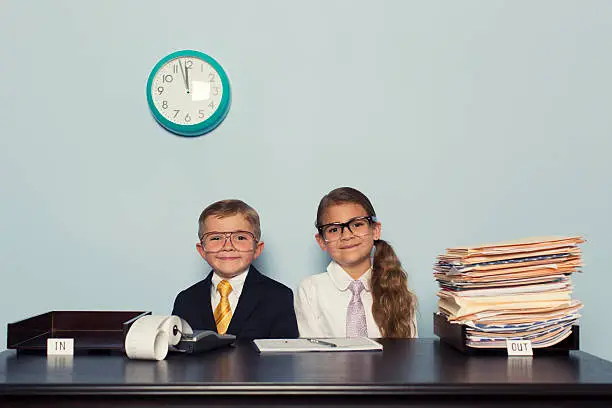Photo of Young Boy and Girl Wearing Business Attire in Office