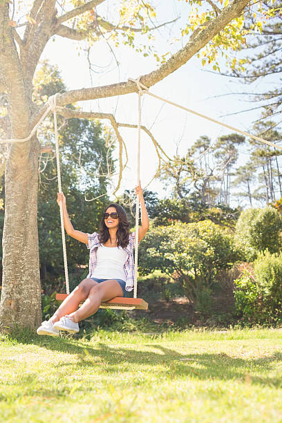 istock Pretty brunette swinging in park 482603218