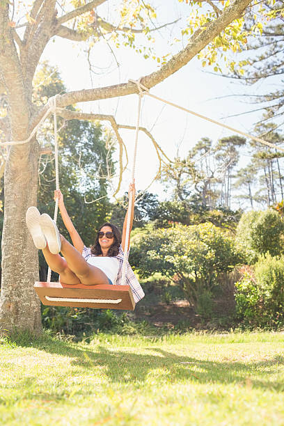 istock Pretty brunette swinging in park 482604042