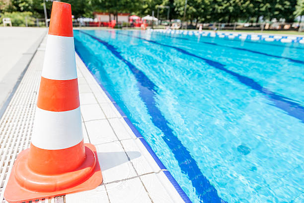 istock swimming pool repair - safety cone on edge 482605910