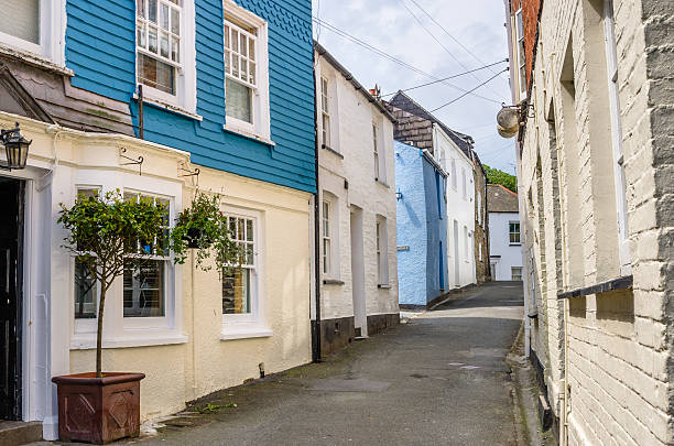 Empty narrow street in a small fishing village in Cornwall, Uk. Colorful old terraced houses line the street.
