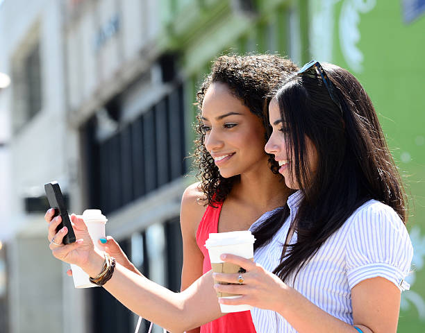 istock Two young women friends with coffe taking selfie 482612018