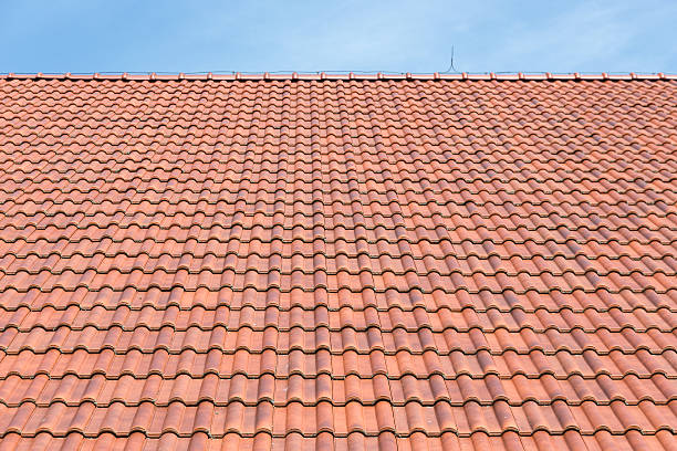 red roof tiles background and blue sky - macro construction building activity roof tile стоковые фото и изображения