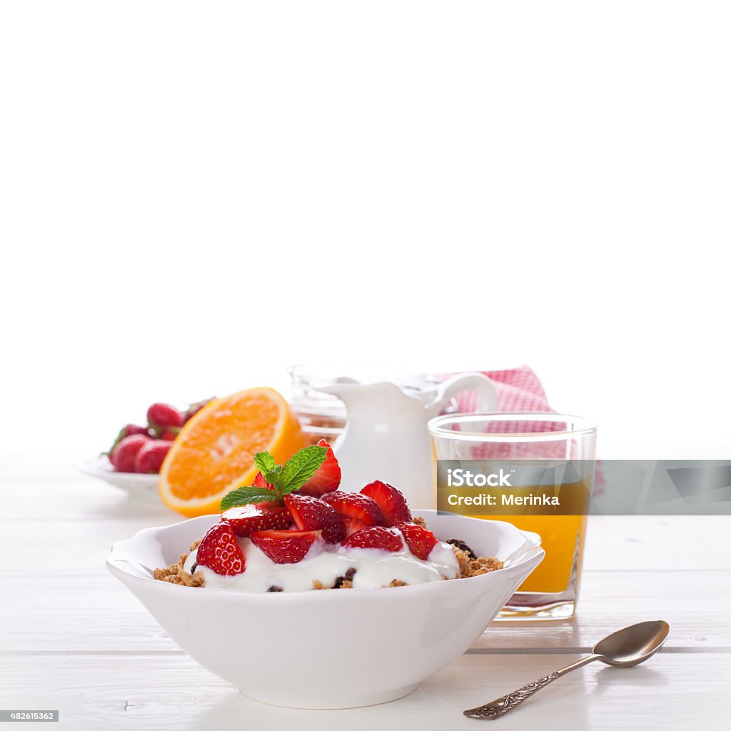 Yogurt with granola or muesli and strawberries Yogurt with homemade granola or muesli and fresh strawberries for healthy morning breakfast, selective focus, over white. Healthy food background with copy space for text. 2015 Stock Photo