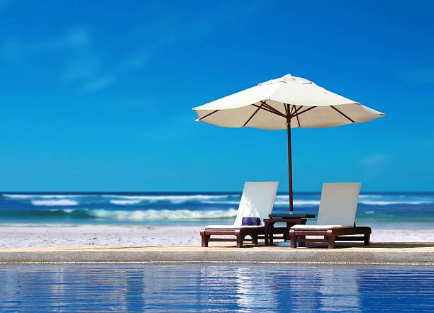 istock Two Chairs with White Umbrella near the Beach 482618579