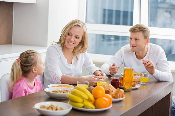 Happy family of three having breakfast at table