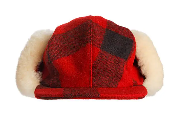 A red and black plaid warm winter hunter's cap with fur ear flaps. Hunter's cap is isolated on a white background. 