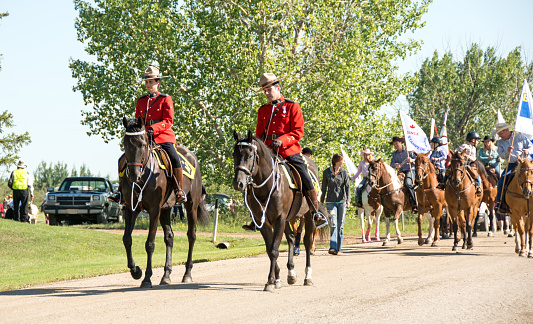 Bruce, Canada - July 26, 2015: Royal Canadian Mounted Police leading a parade in a small rural community. The people behund the RCMP are local horsemen.