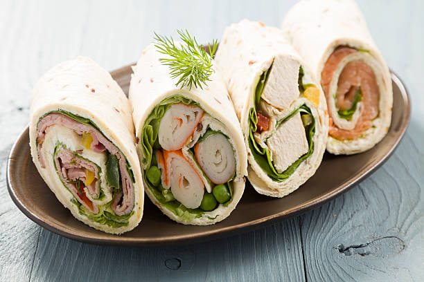Mix of wraps with ham, chicken, salmon and crab served on a plate