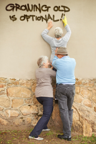 Shot of mischievous pensioners spray-painting graffiti on a wall