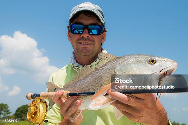 Fisherman Holding Fish And Fly Rod Stock Photo - Download Image Now - Charleston - South Carolina, South Carolina, Adult