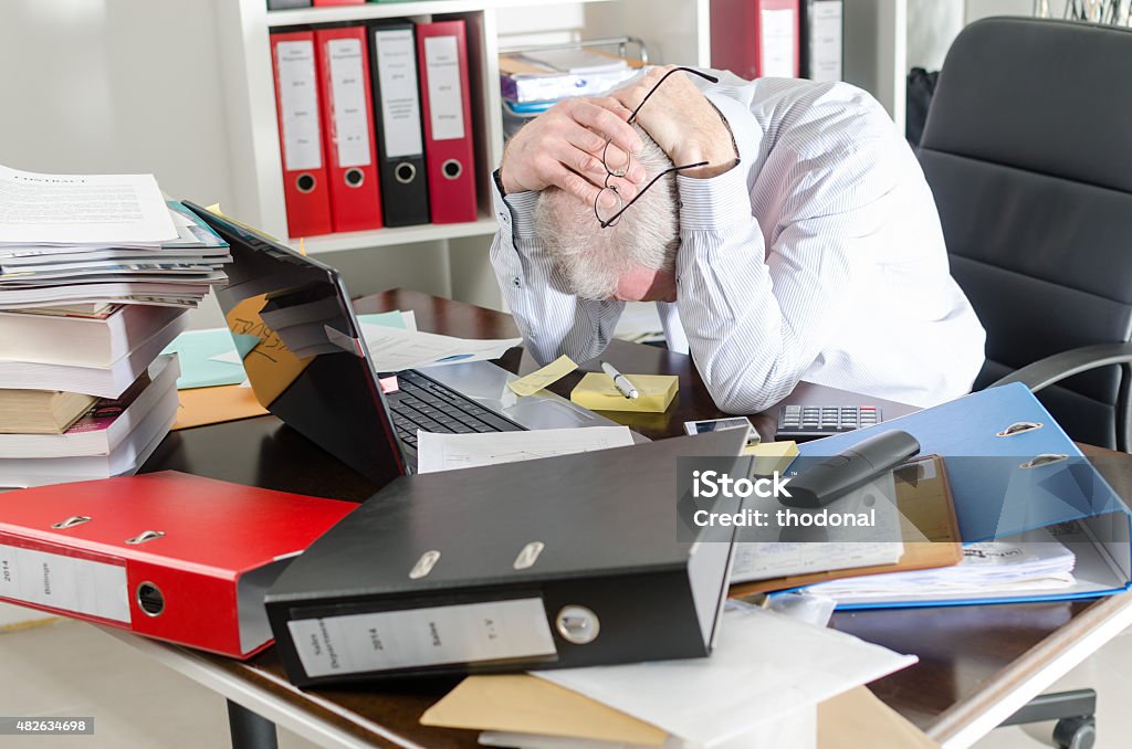 Stressed businessman Stressed businessman holding his head in his hands Messy Stock Photo