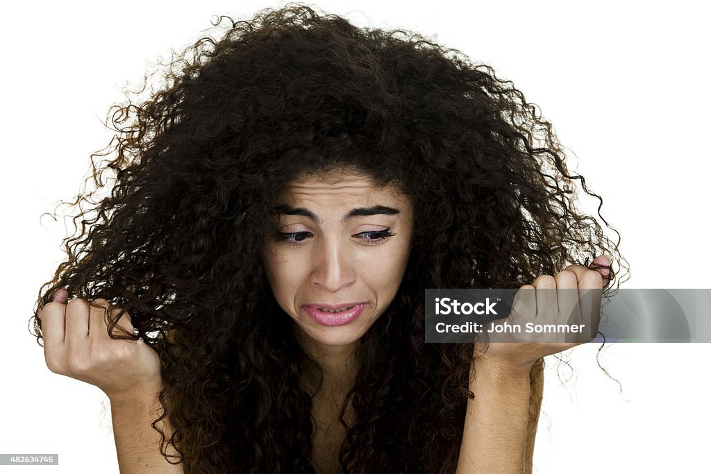 Girl having a bad hair day Headshot of a woman with a sad expression and looking at her curly hair  20-24 Years Stock Photo