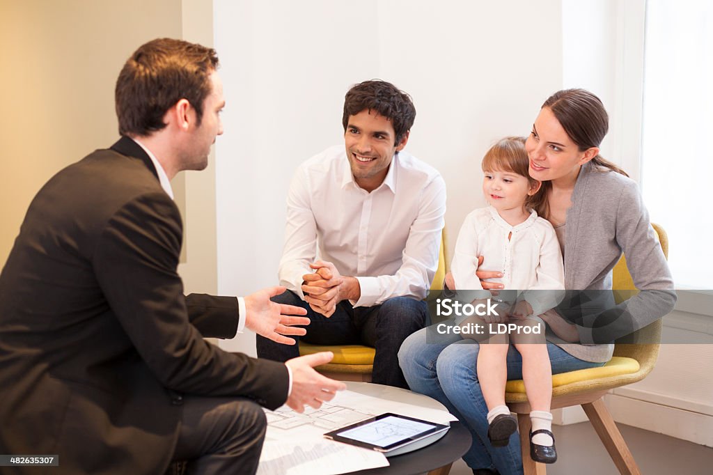 Young Family meeting real-estate agent to buy property couple children house investment advisor Family Stock Photo