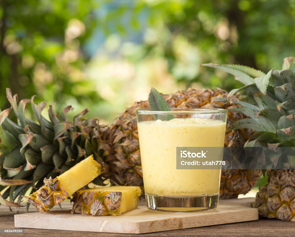 pineapple juice Pineapple juice and pineapple slice placed on a wooden table. Pineapple Stock Photo