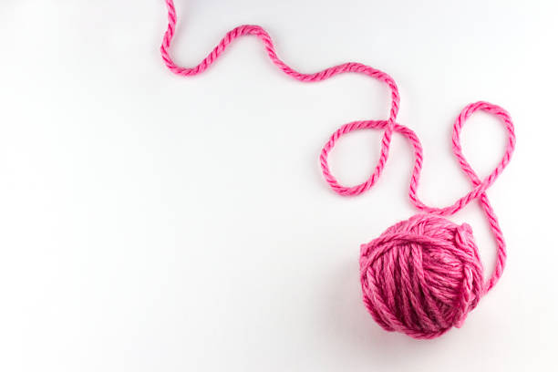 Top view of pink yarn ball with woolen thread Top view of pink yarn ball with woolen thread on white background skein stock pictures, royalty-free photos & images