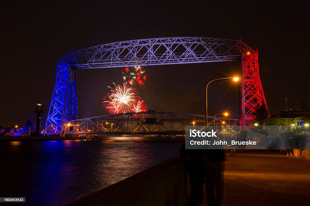 Duluth Lift Bridge Fireworks A lift bridge lit up in red, white, and blue with fireworks on Independence Day. Lake Superior Stock Photo