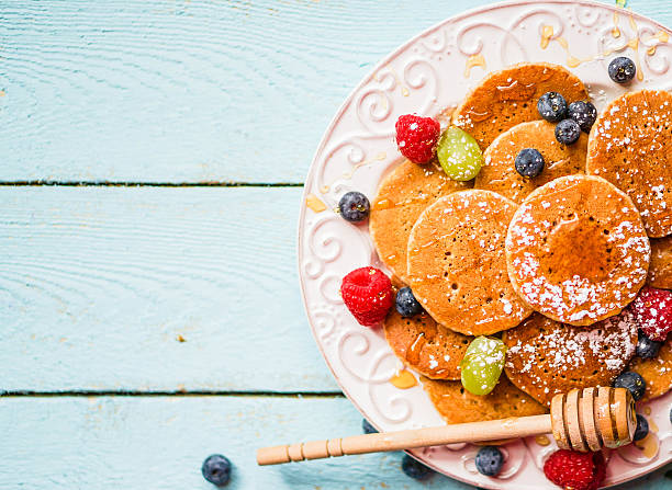 istock Pancakes with berries on wooden background 482644061