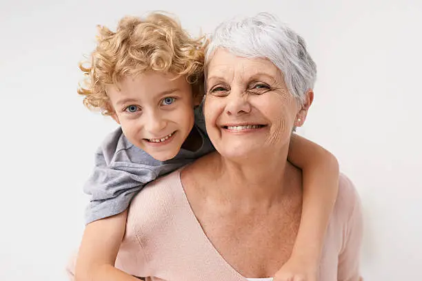 Portrait of a grandmother giving her grandson a piggyback ride