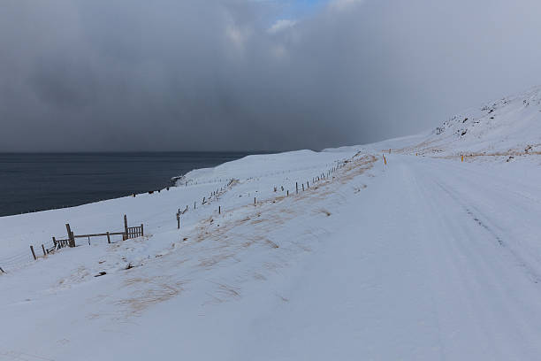 istock snow covered road with stormy sky 482644629