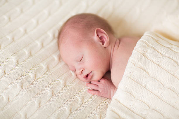 istock Tiny newborn baby sleeping on a soft knitted blanket 482645283