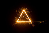 Mild glowing triangle sparks on dark background.