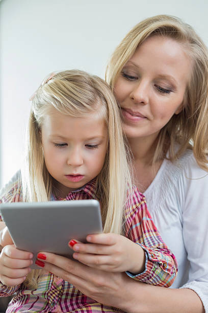 istock Loving woman with daughter using digital tablet at home 482646869