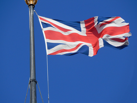 Waving British flag with blue sky as background