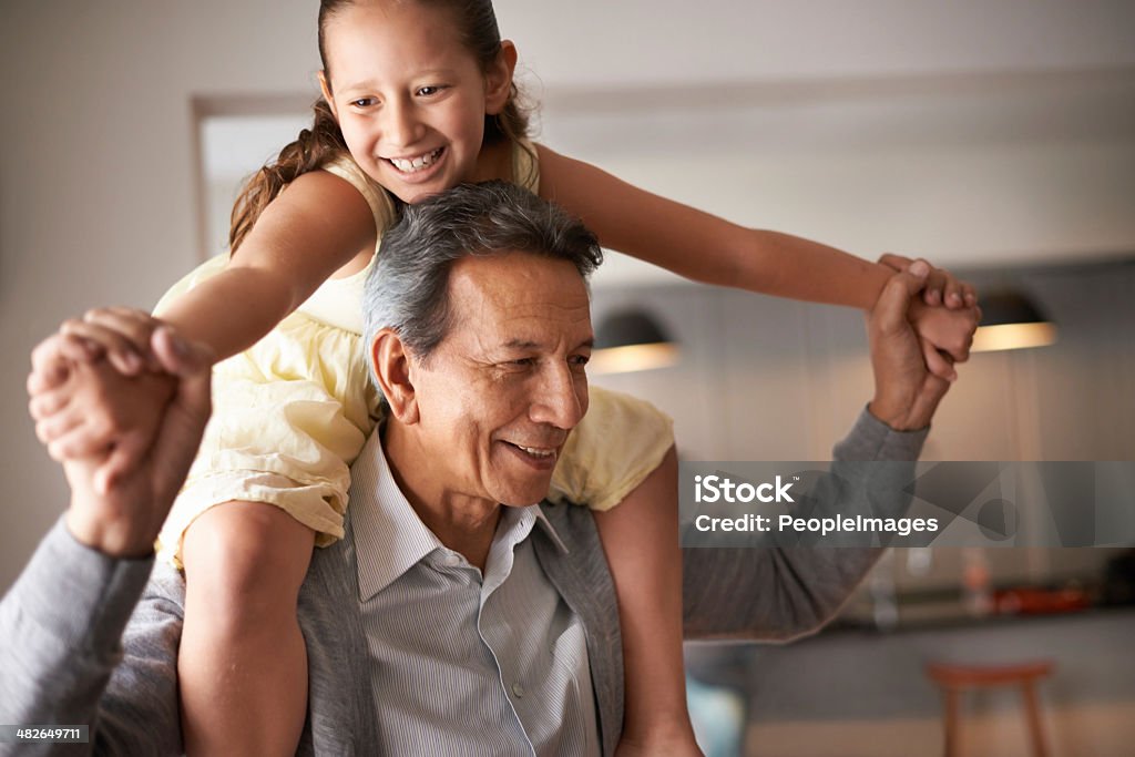 Grandpa is so much fun Shot of a grandfather giving his little granddaughter a piggyback ride Grandparent Stock Photo