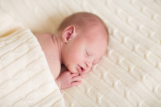 istock Tiny newborn baby sleeping on a soft knitted blanket 482650305