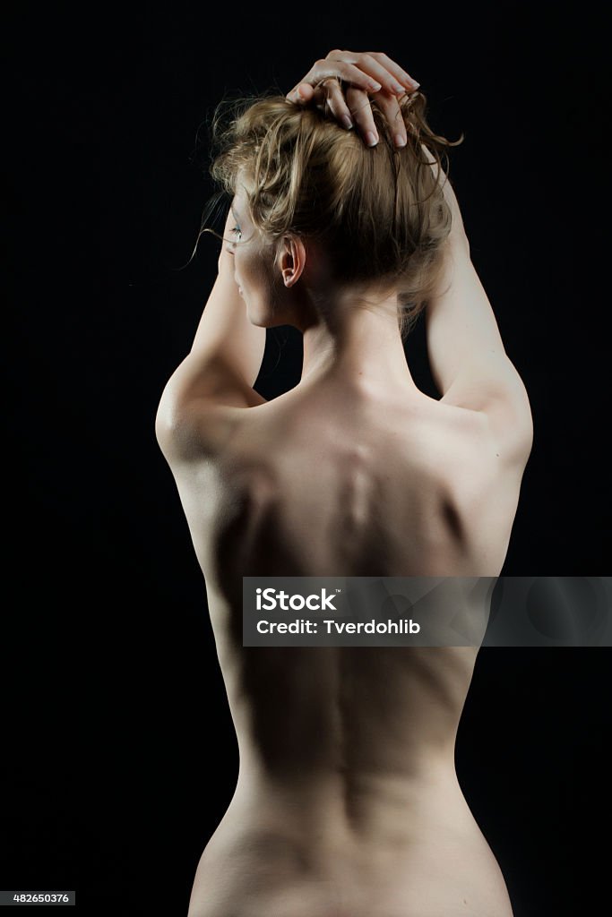 Thin naked female body Beautiful thin naked female body perfect shape sitting with back view on black background, vertical picture Naked Stock Photo