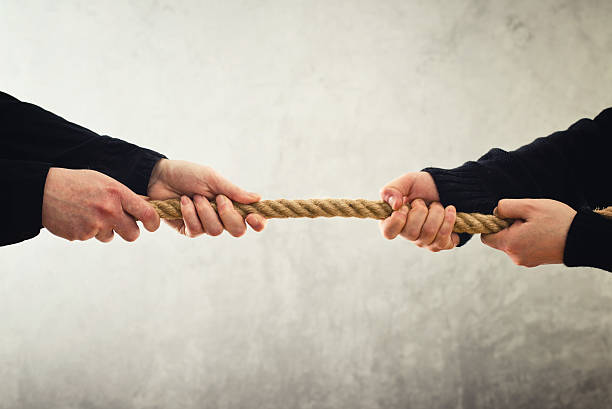 istock Tug of war. Hands pulling rope to opposite sides 482651255