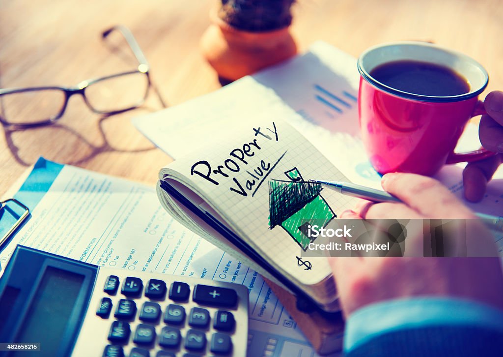 Businessman Notepad Property Value Concept ***NOTE TO INSPECTOR: All visible graphics are our own design, and were produced for this particular shoot.***					 2015 Stock Photo