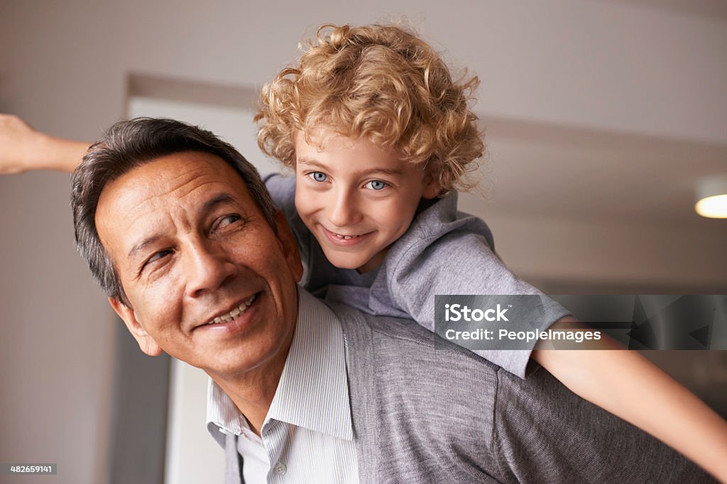 Grandchildren are a blessing! A grandfather carrying his grandson on his back Grandfather Stock Photo