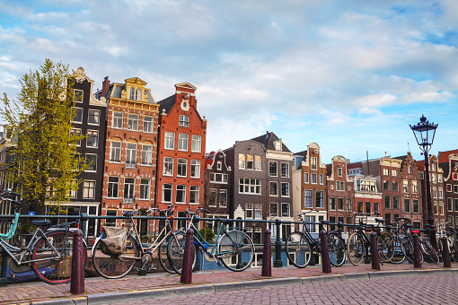 Shopping street with woman on Dutch cargo bike at summer sunset, Haarlemmerdijk, Amsterdam, The Netherlands.