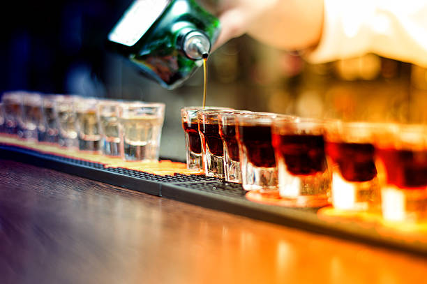 camarero verter fuerte bebida sin alcohol en gafas - tequila reposado fotografías e imágenes de stock