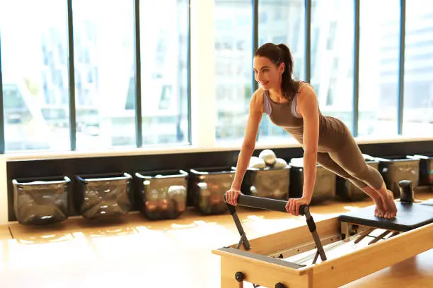 Photo of Brunette Woman Practicing Pilates in Studio